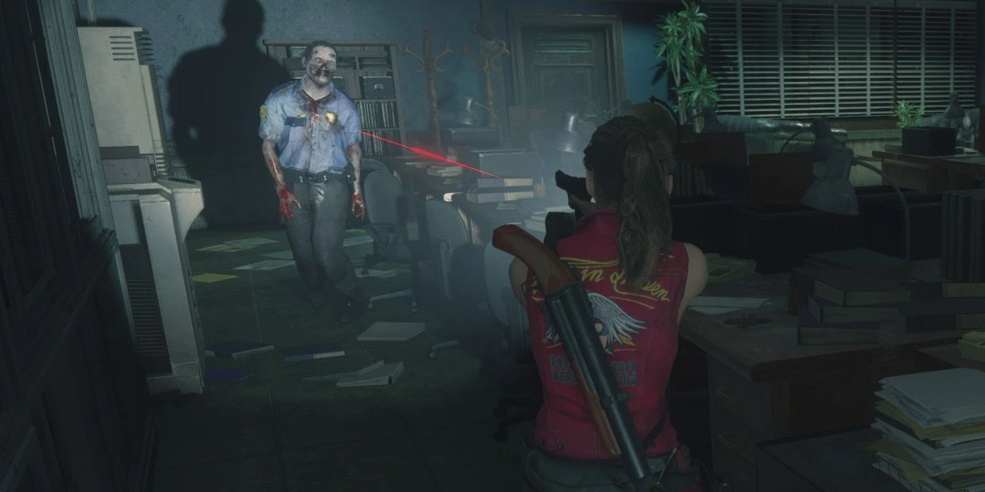 Claire Redfield pointing a gun at a zombie in a police uniform in a dark office