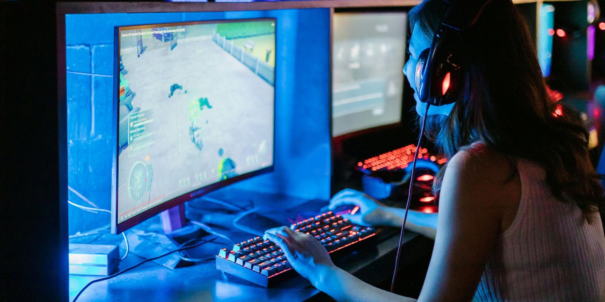Large Curved Monitor With Someone Playing With Blue Lighting And Red RGB Lit Keyboard