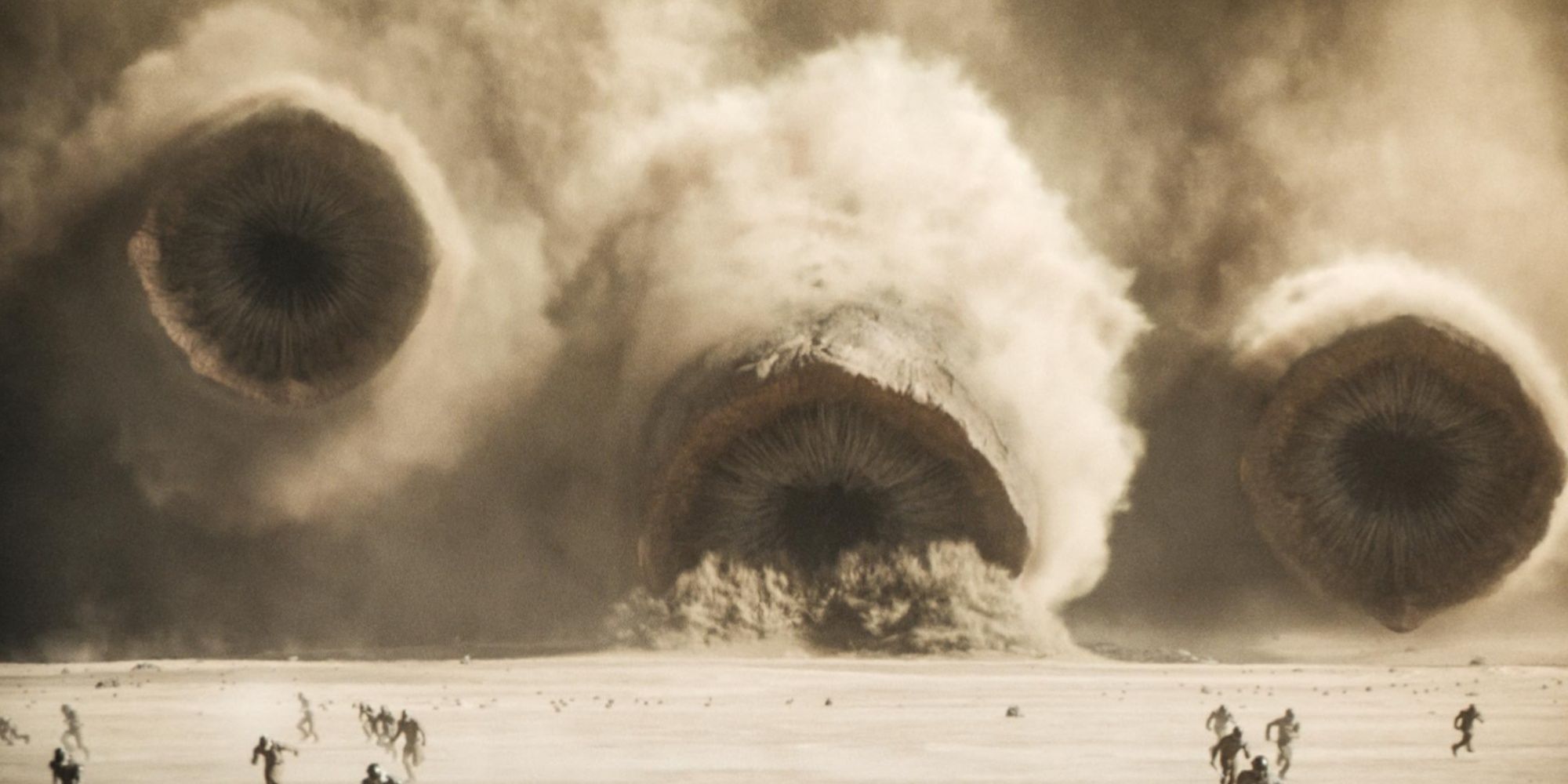 All three sandworms in Dune: Part Two emerging simultaneously from the sands of Arrakis to attack the Emperor's forces.