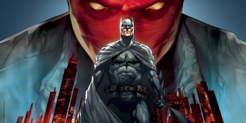 Batman stands under a looming Red Hood, Gotham behind him.