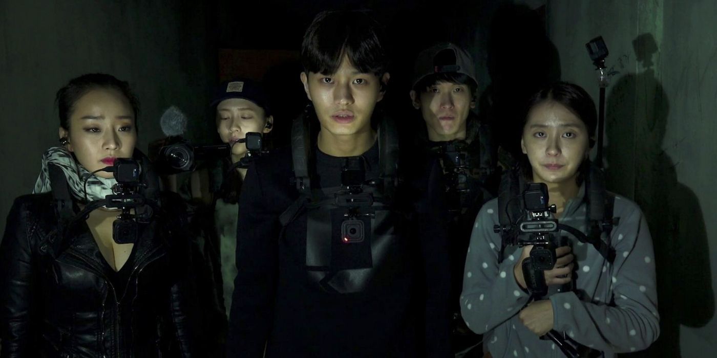 A YouTube crew stands together in the dark, all holding cameras.