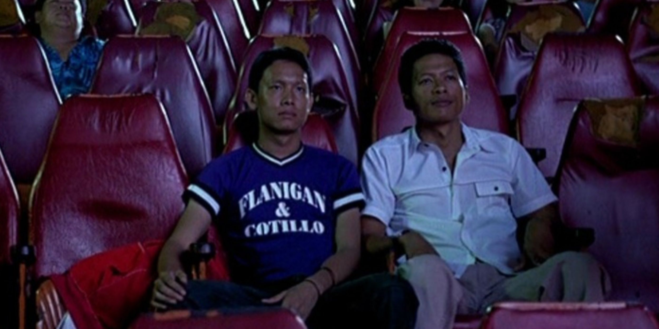 Two men sit together in an almost empty cinema.