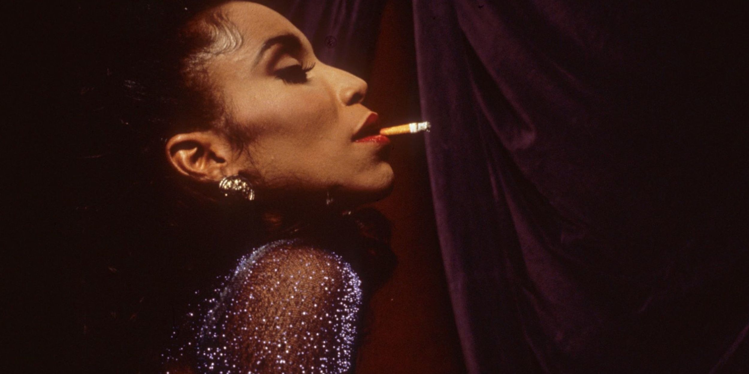 An elegant woman smokes a cigarette in the film Paris Is Burning.