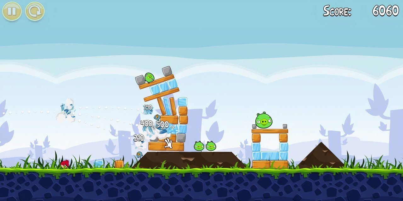 Gameplay screenshot of Angry Birds, showing the pigs' structures being attacked by the red bird.