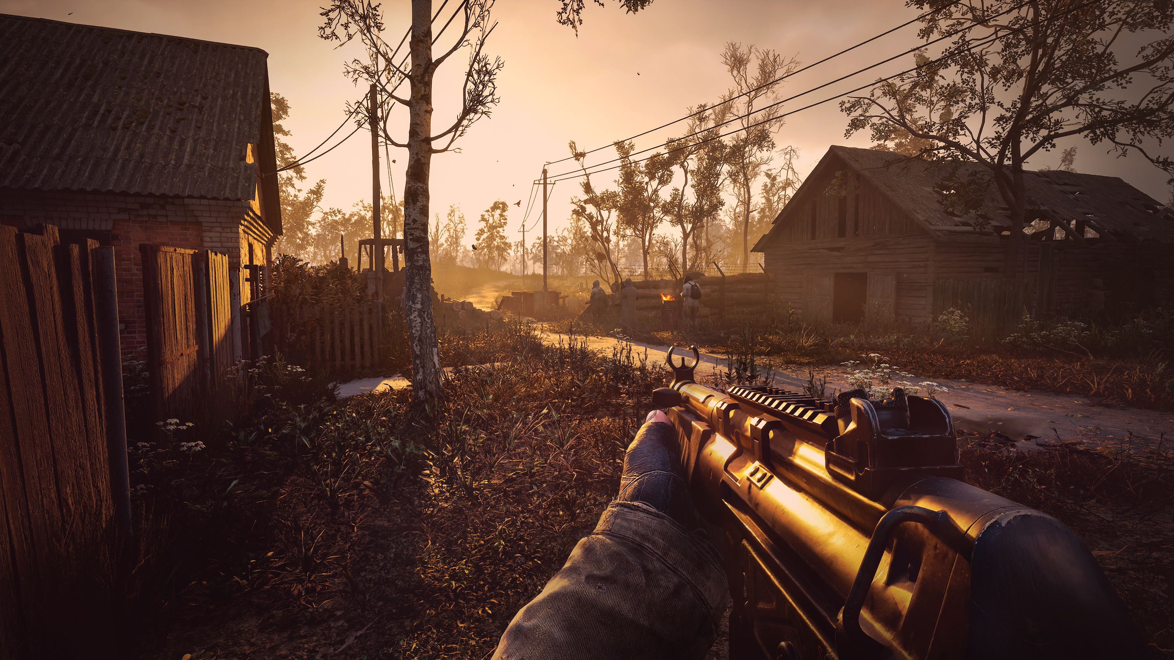 The player enters a small abandoned village as the sun sets in Stalker 2. 