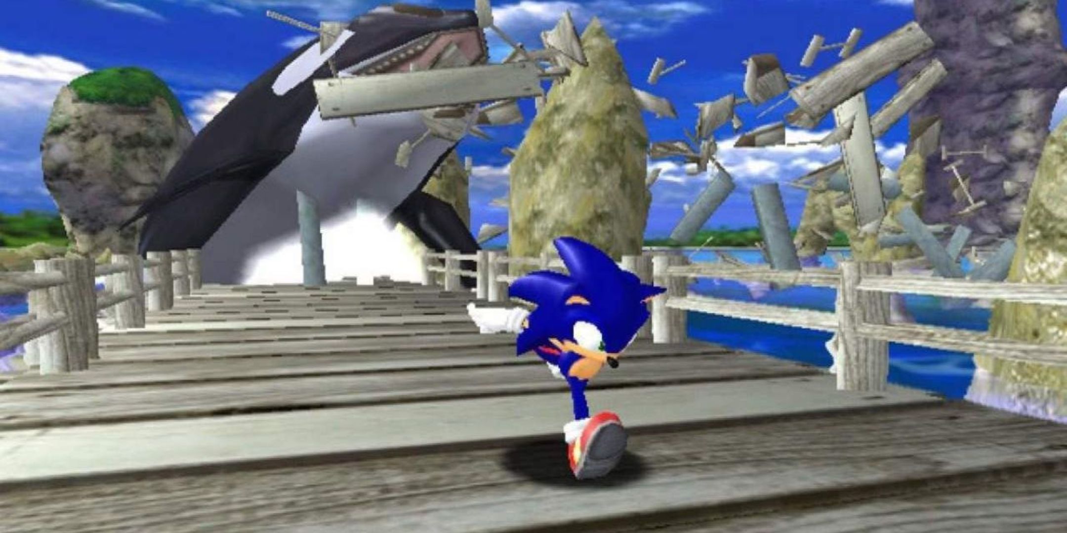 Sonic runs down the Emerald Coast boardwalk as an orca smashes it behind him in Sonic Adventure for the Sega Dreamcast.
