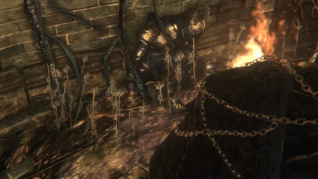 Knight in armour slumped against a wall in Bloodborne Chalice Dungeon.