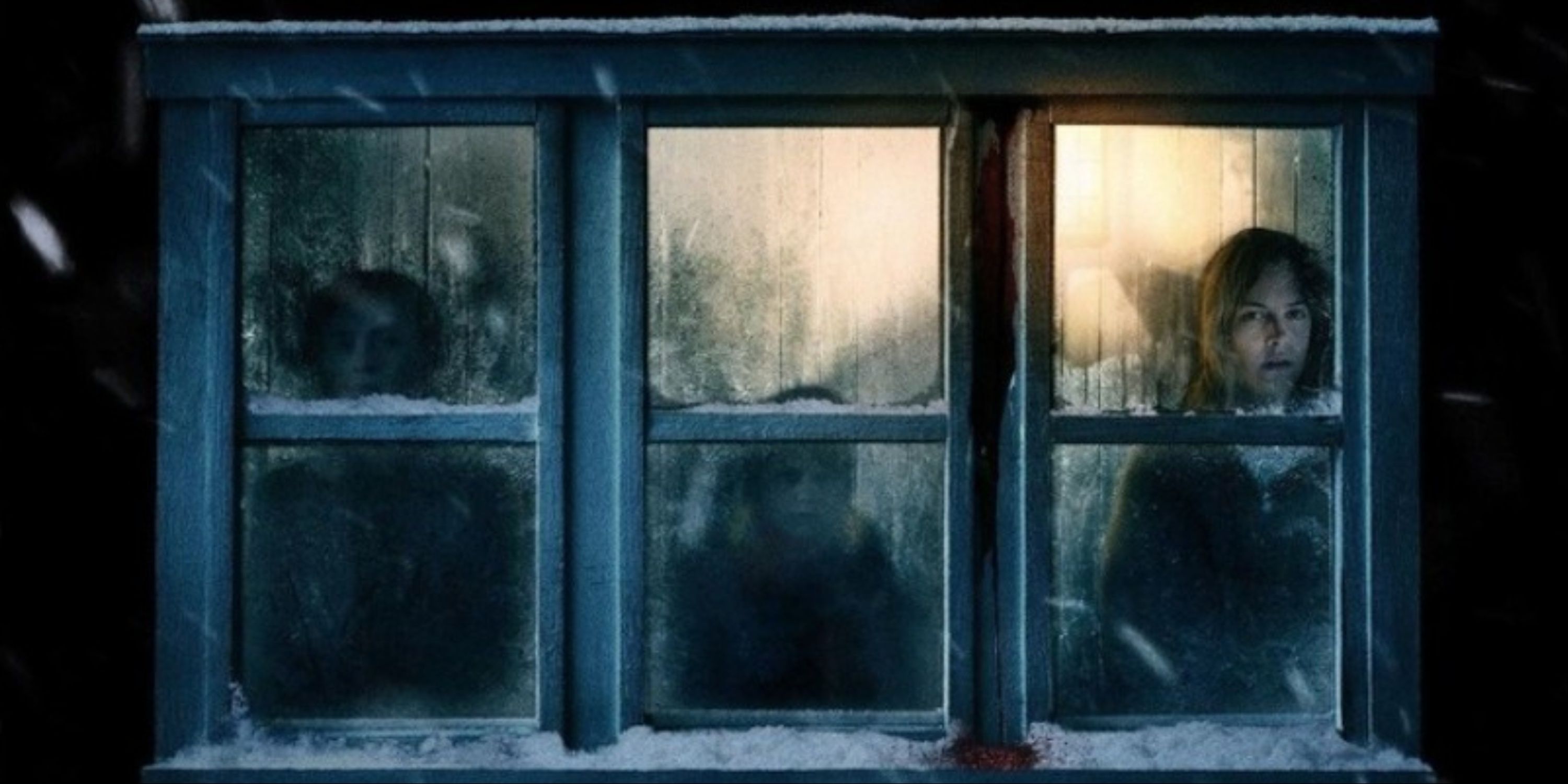 Riley Keough, Jaeden Martell, and Lia McHugh seen through snowed-in windows on the main art for The Lodge.
