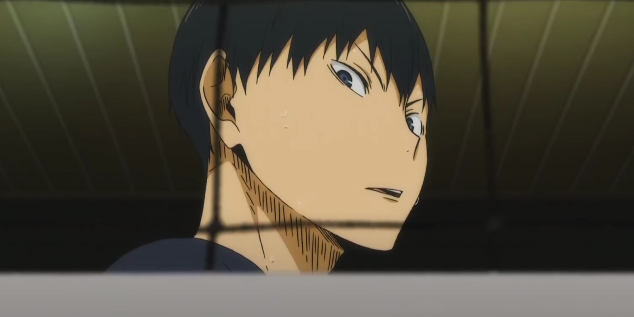Tobio Kageyama is looking down through the net in Haikyu.