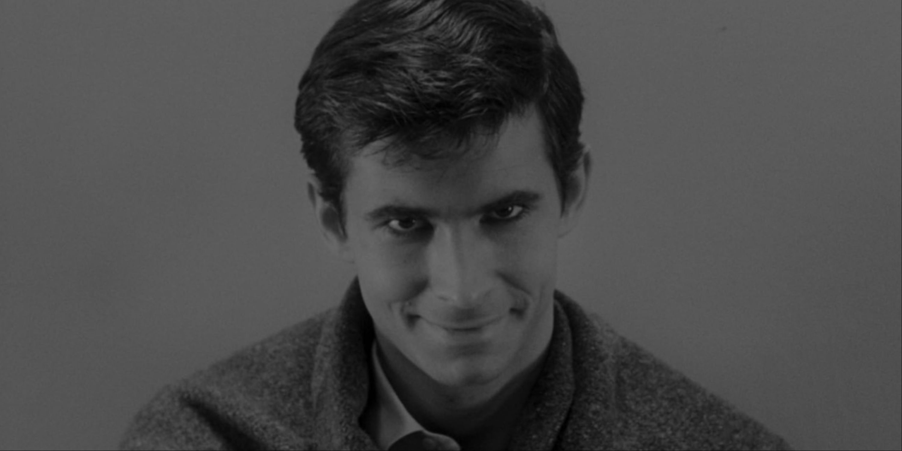A close-up of Anthony Perkins as Norman Bates in the ending scene of Psycho.