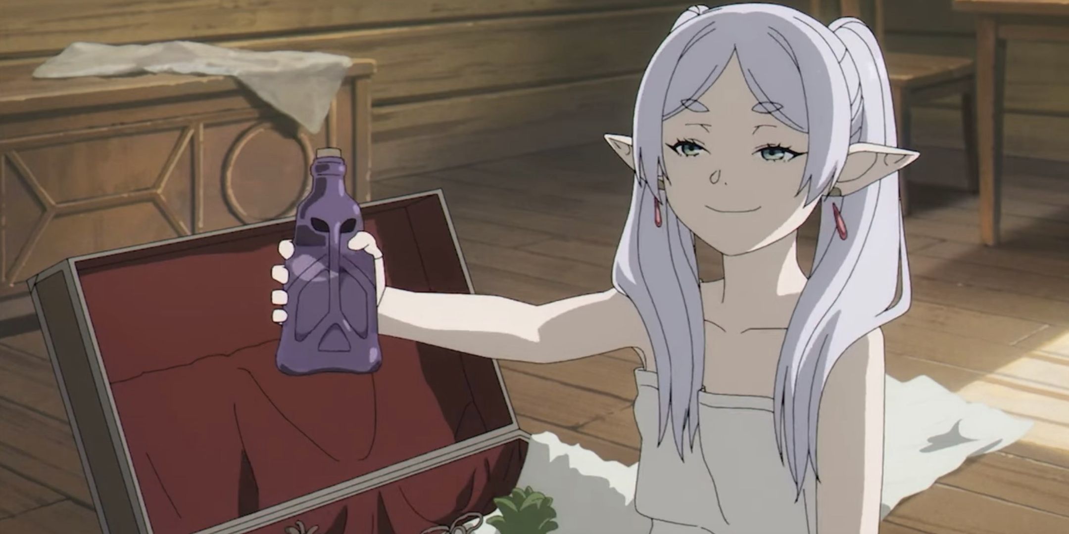 Frieren offers a potion to Fern for Stark's birthday as she smiles smugly in Frieren Beyond Journey's End.