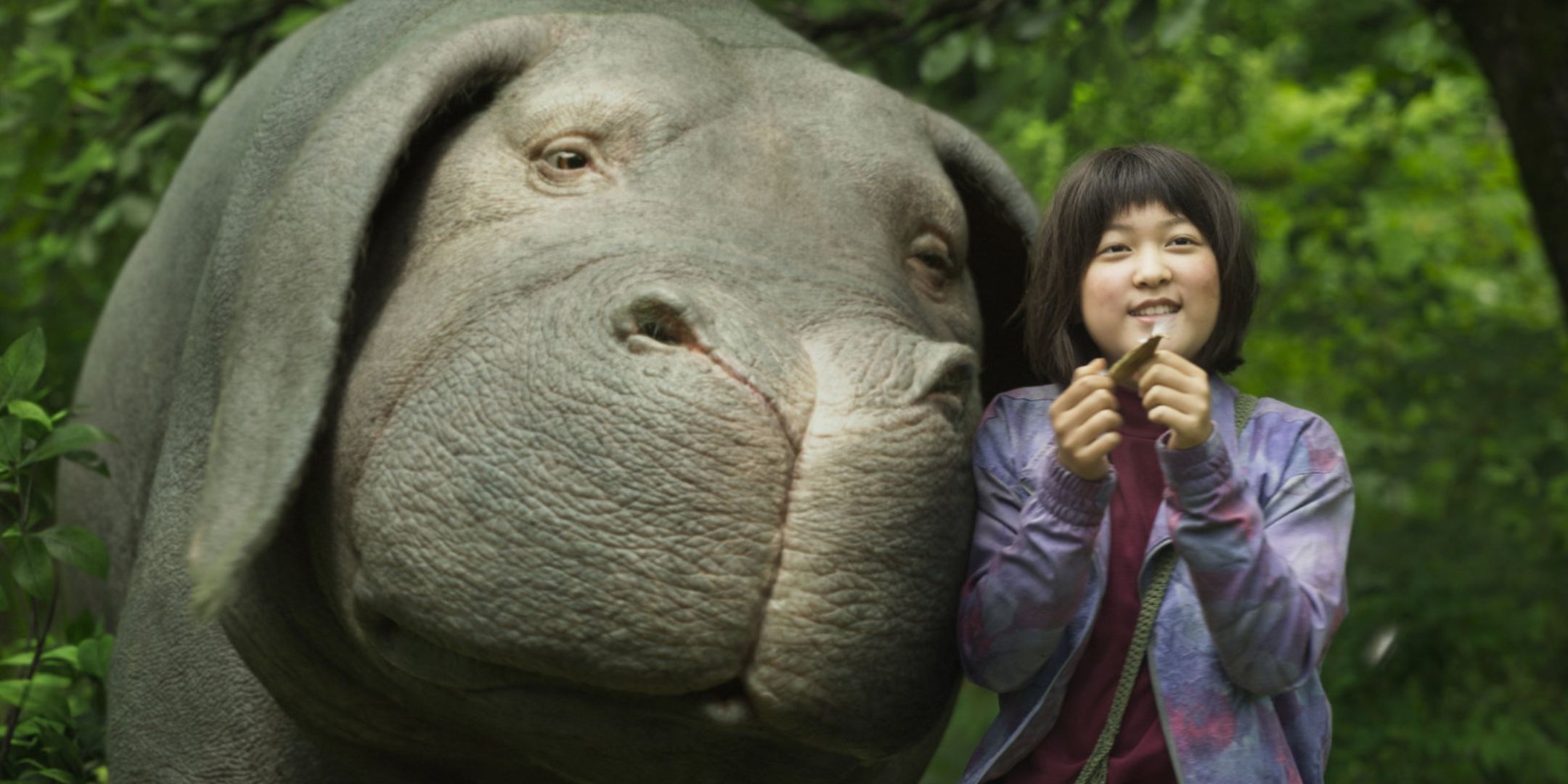 A girl next to a big monster smiling together.