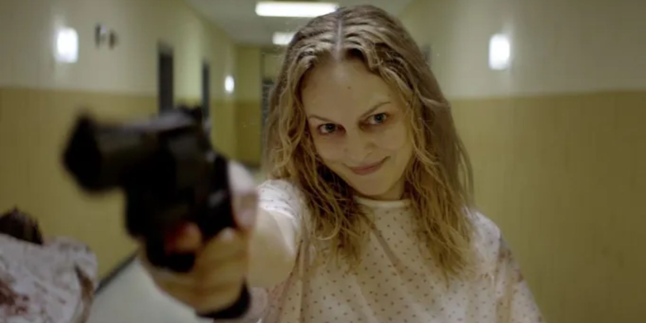 Elizabeth Derby points a gun. 