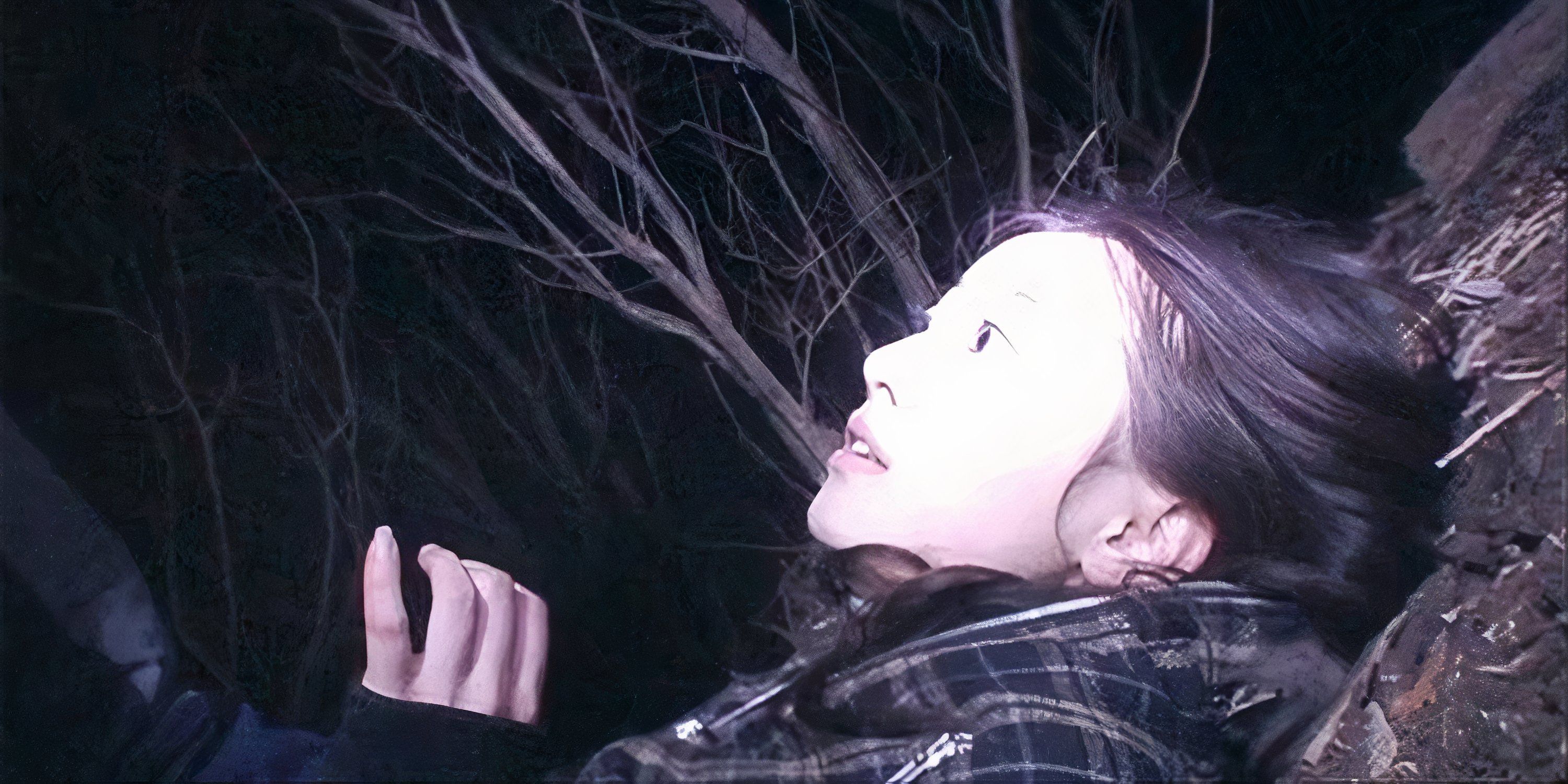 Marika looks shocked as she lies on the ground in Noroi: The Curse.