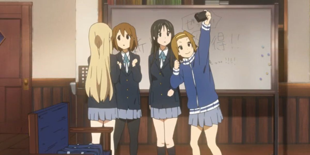 The cast of K-On prepare to take a picture together.
