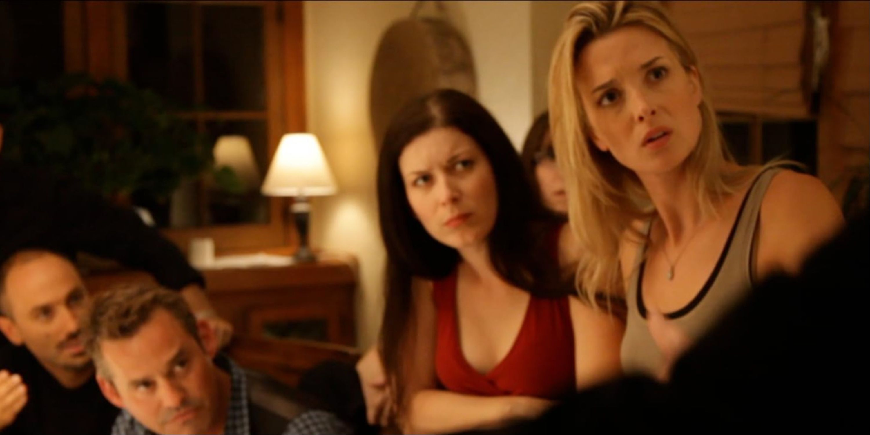 The main characters in Coherence gathered around the dining table with confused expressions.