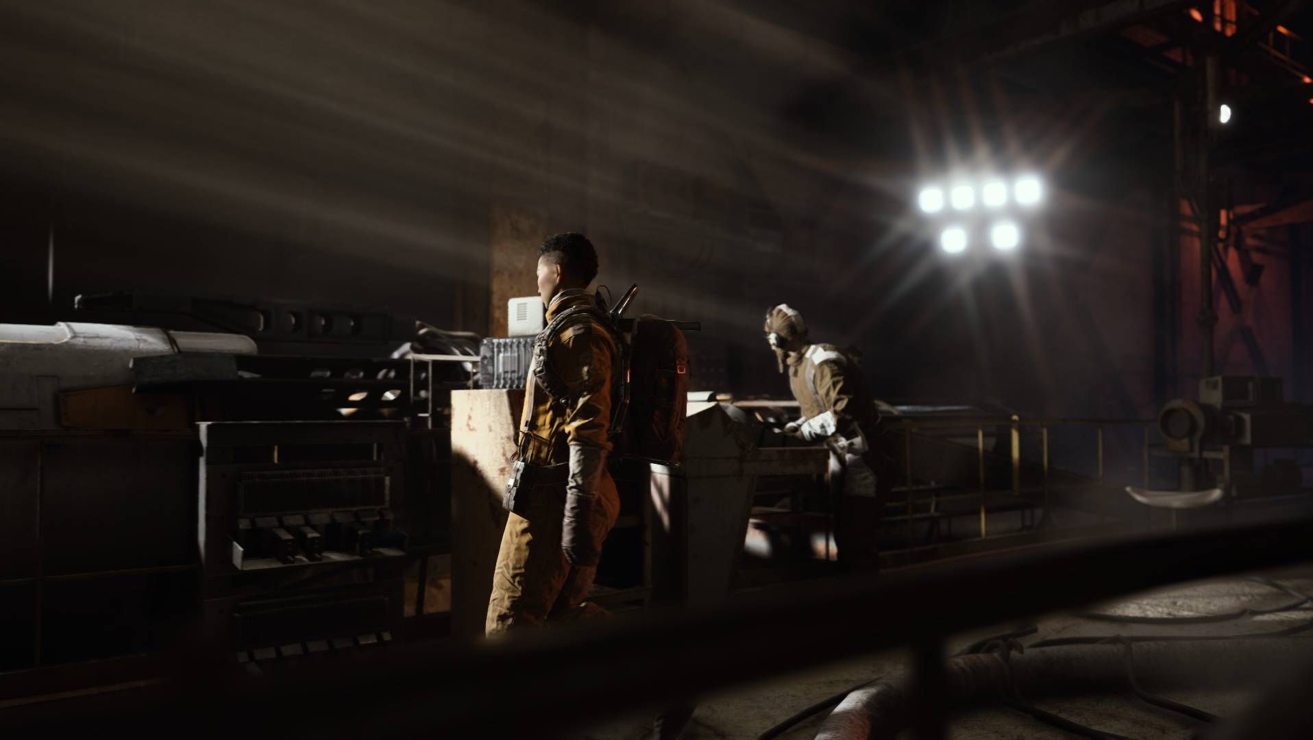 Arc Raiders - technicians at work on some machinery in a dark hall.