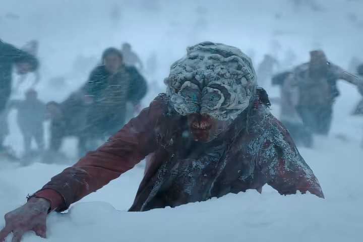 infected in the snow in the last of us season 2 with horde of humans running away.