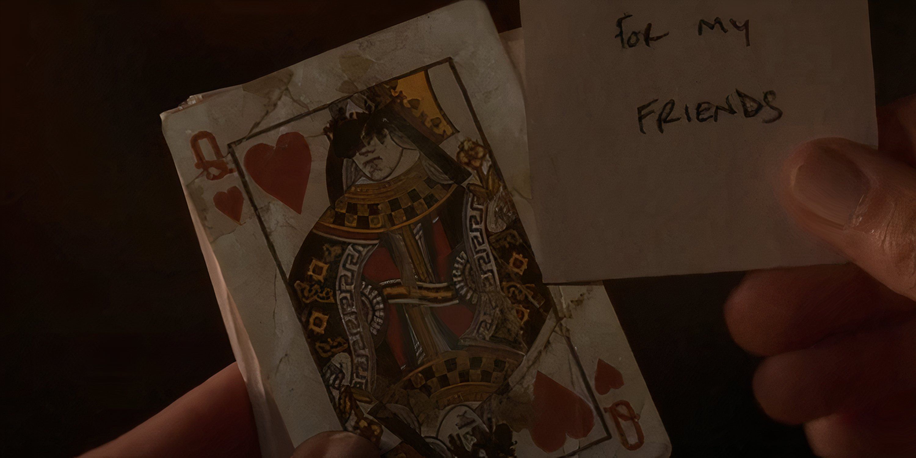 Lottie holds a Queen of Hearts card with its eyes scratched out.