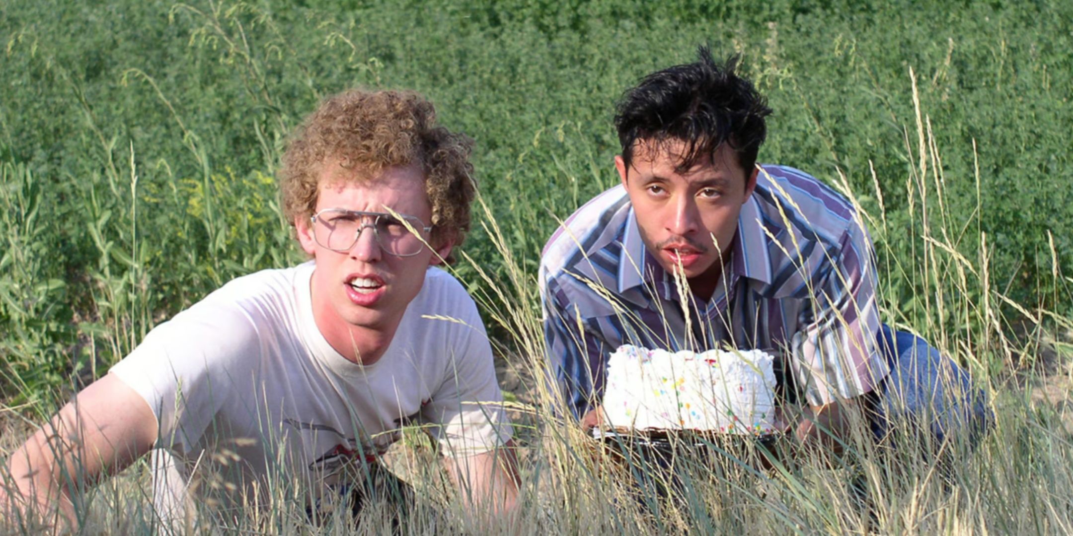 Napoleon Dynamite and Pedro wait in the tall grass with a cake.