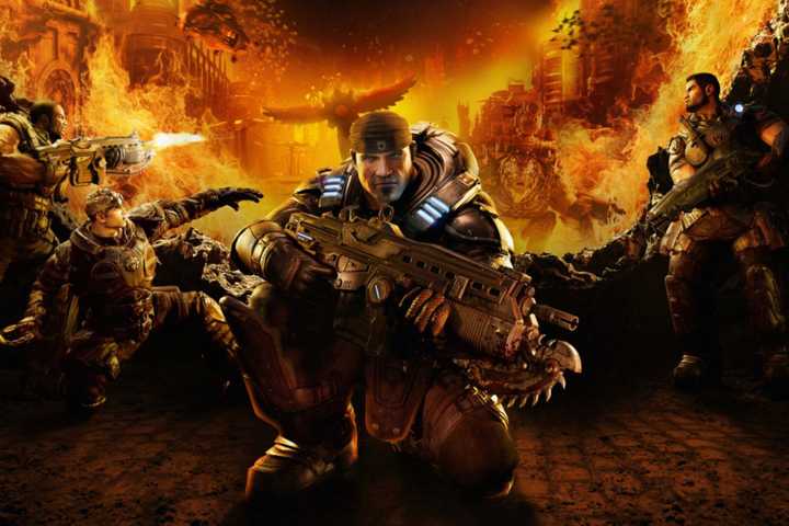 Cover art for Gears of War: Reloaded. It shows futuristic soldiers in a violent setting, with fire everywhere. They are taking cover and shooting at monsters