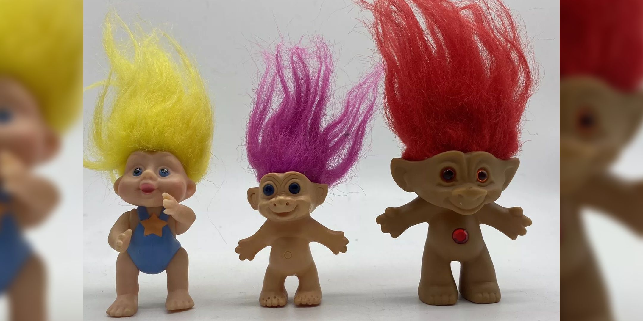 Three Trolls toys lined up.