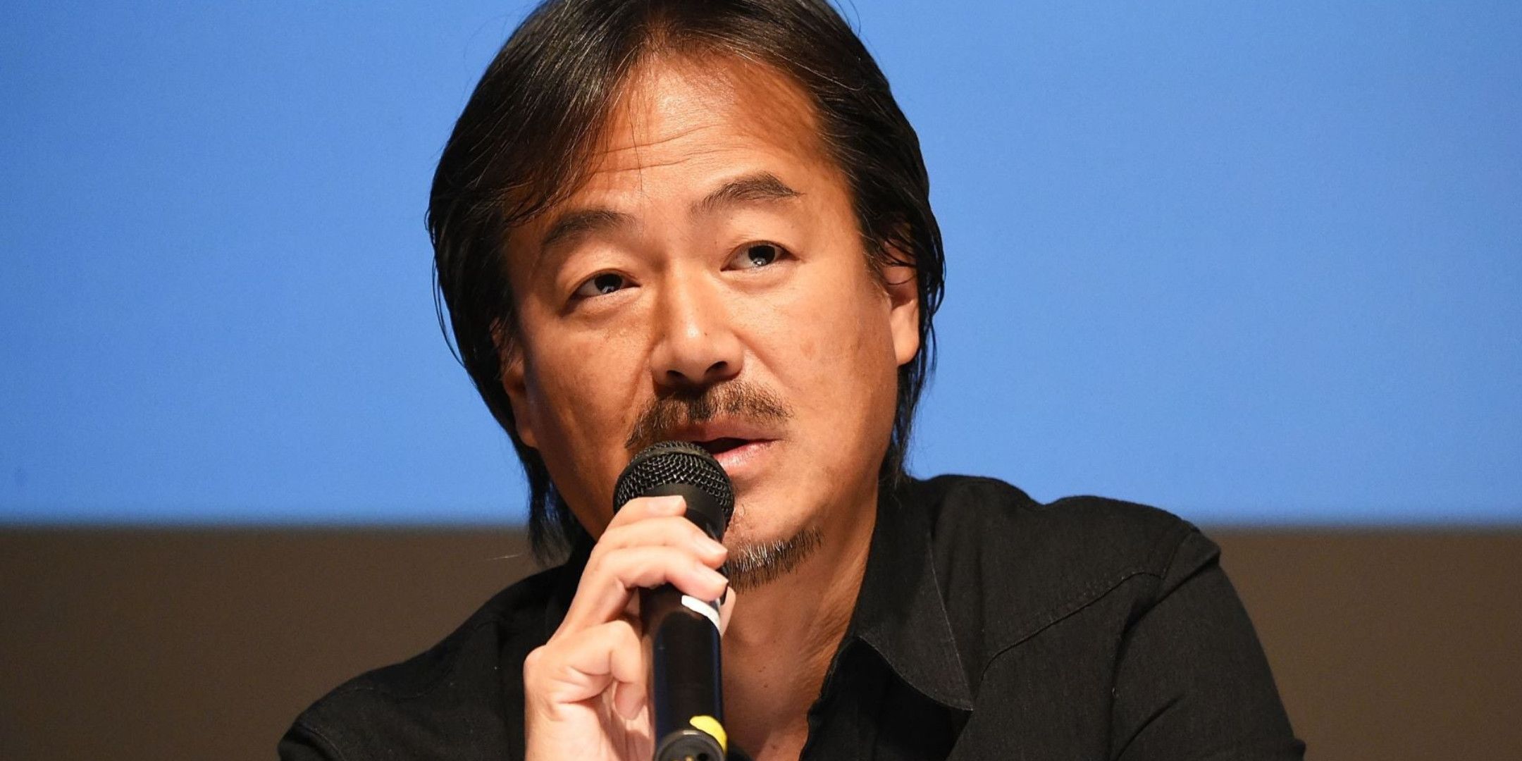 A close up shot of Hironobu Sakaguci talking into a mic.