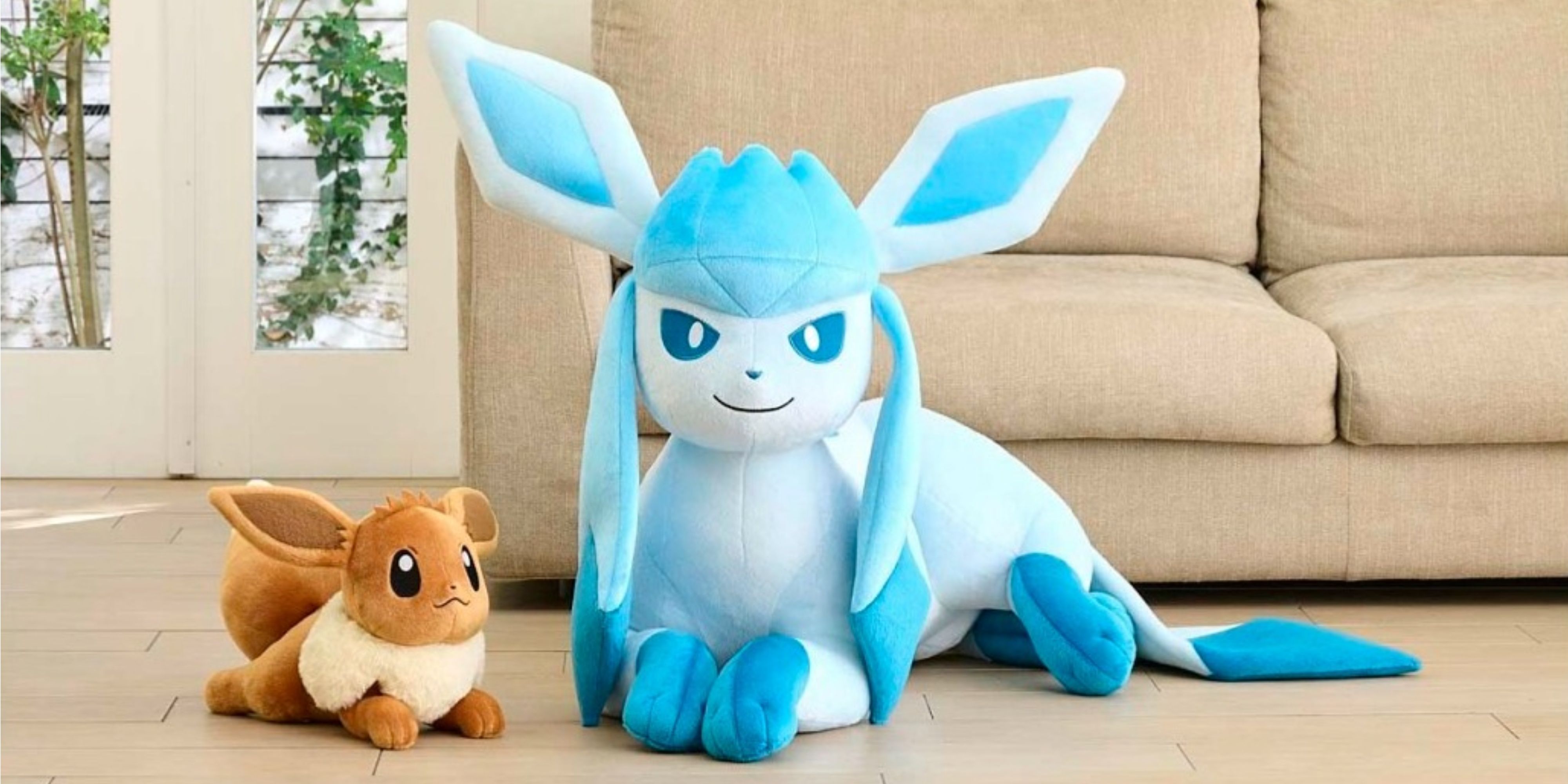 life size glaceon plush next to a little eevee plush.