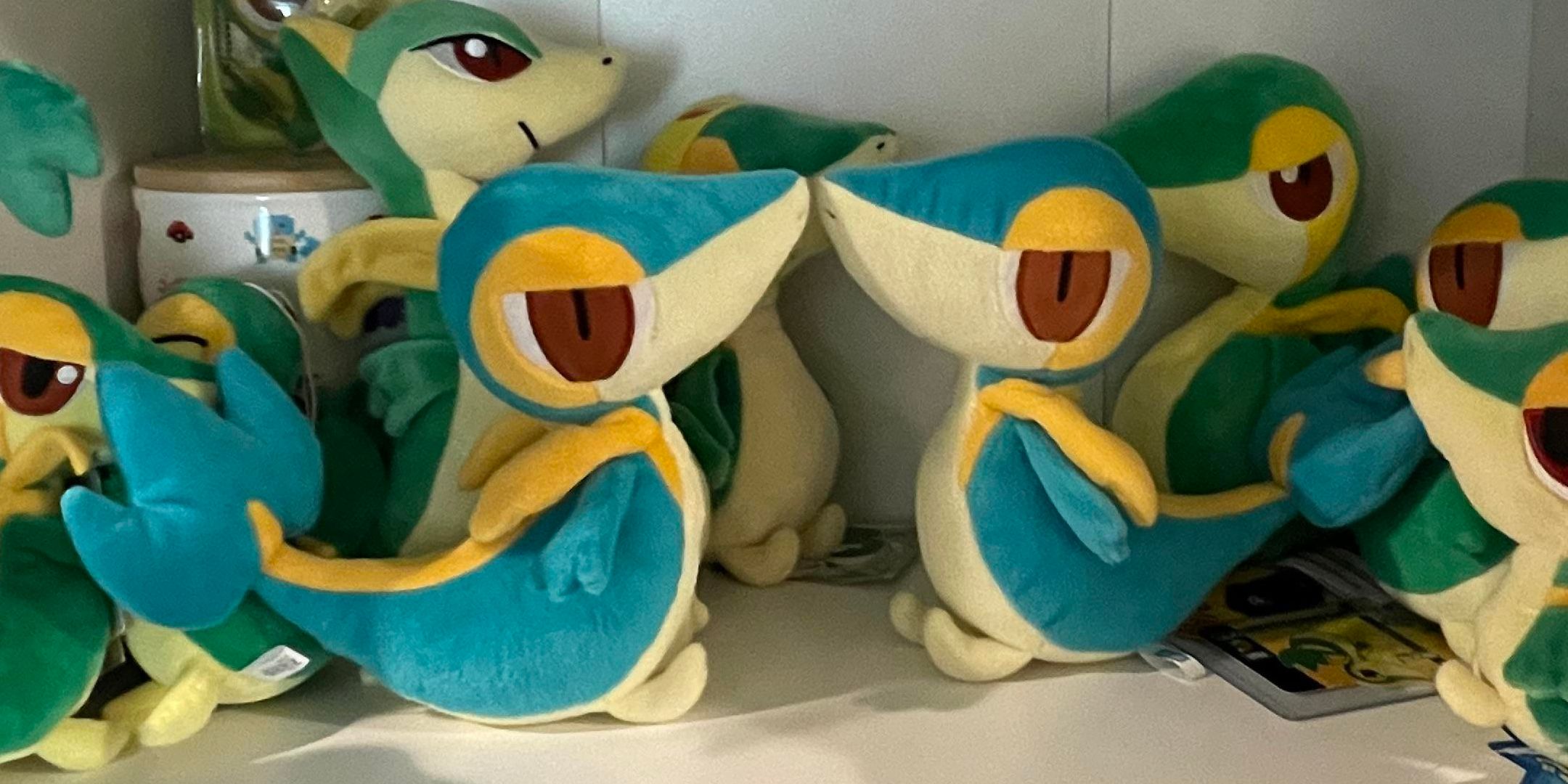 Two shiny snivys on a shelf with normal snivys.