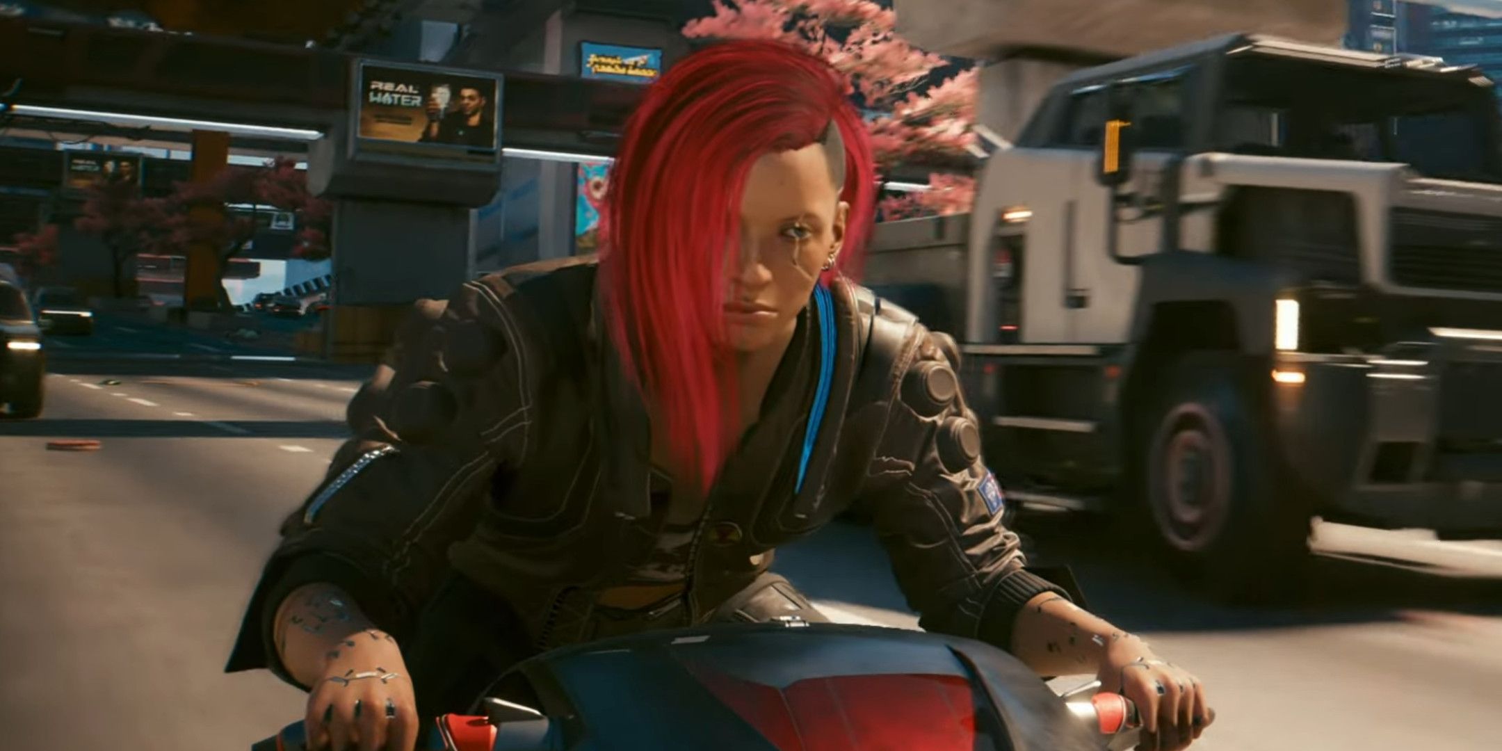 A woman with red hair riding a motorbike on a highway.