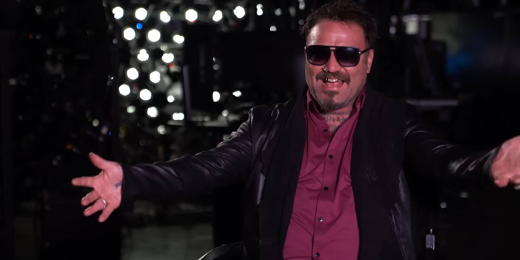 Bam Margera Wearing Sun Glasses And A Red Shirt.