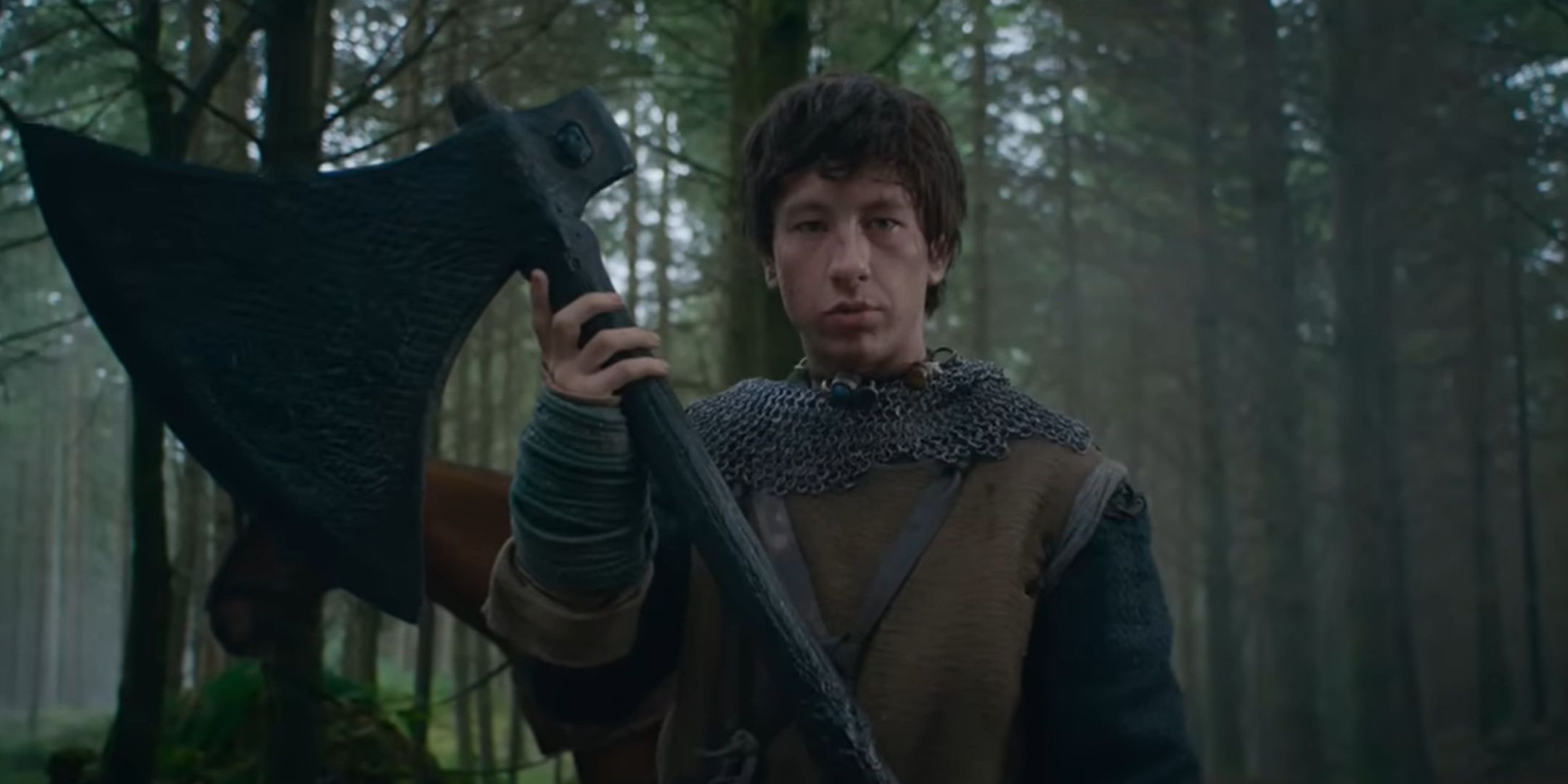 Barry Keoghan hoists a huge ax in The Green Knight.