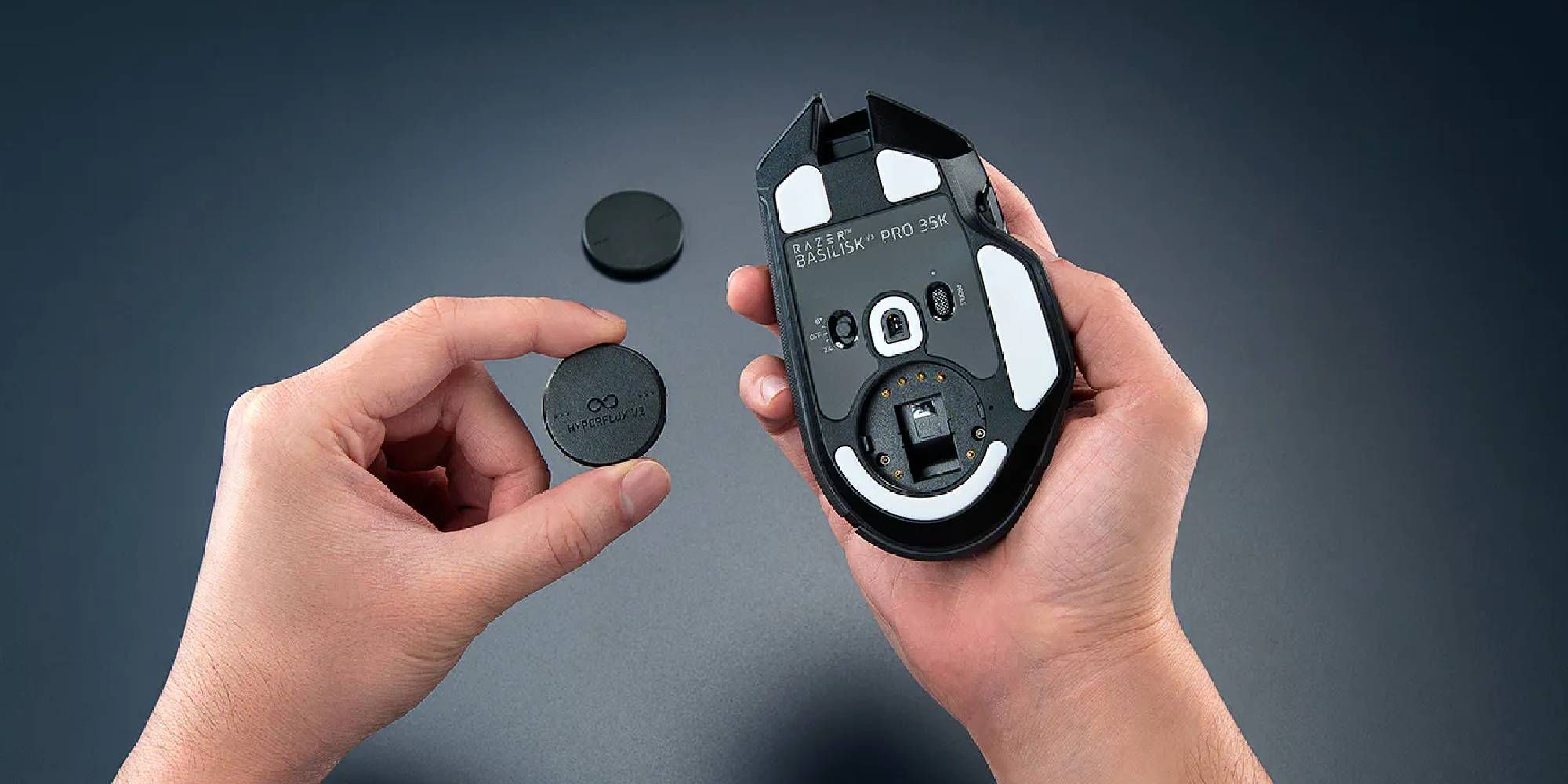 Hands Inserting HyperFlux Wireless Puck In Razer Basilisk Mouse.