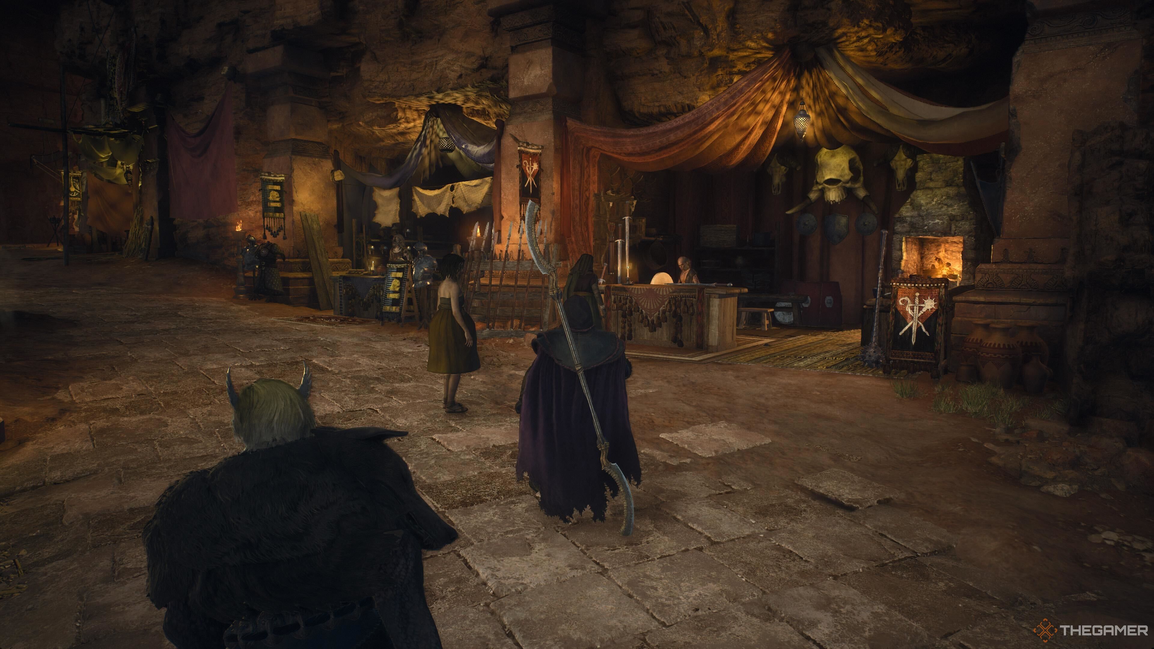 A screenshot from Dragon's Dogma 2 showing the different shops located next to each other in a line in Bakbattahl. Other character can be seen walking and perusing in the market.