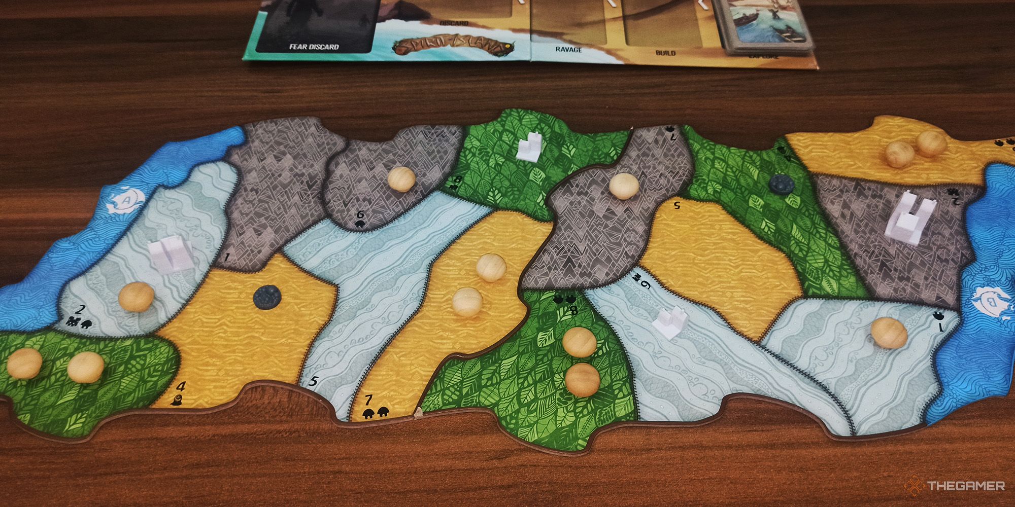 The player assembles the island boards and places the pieces onto them in Spirit Island