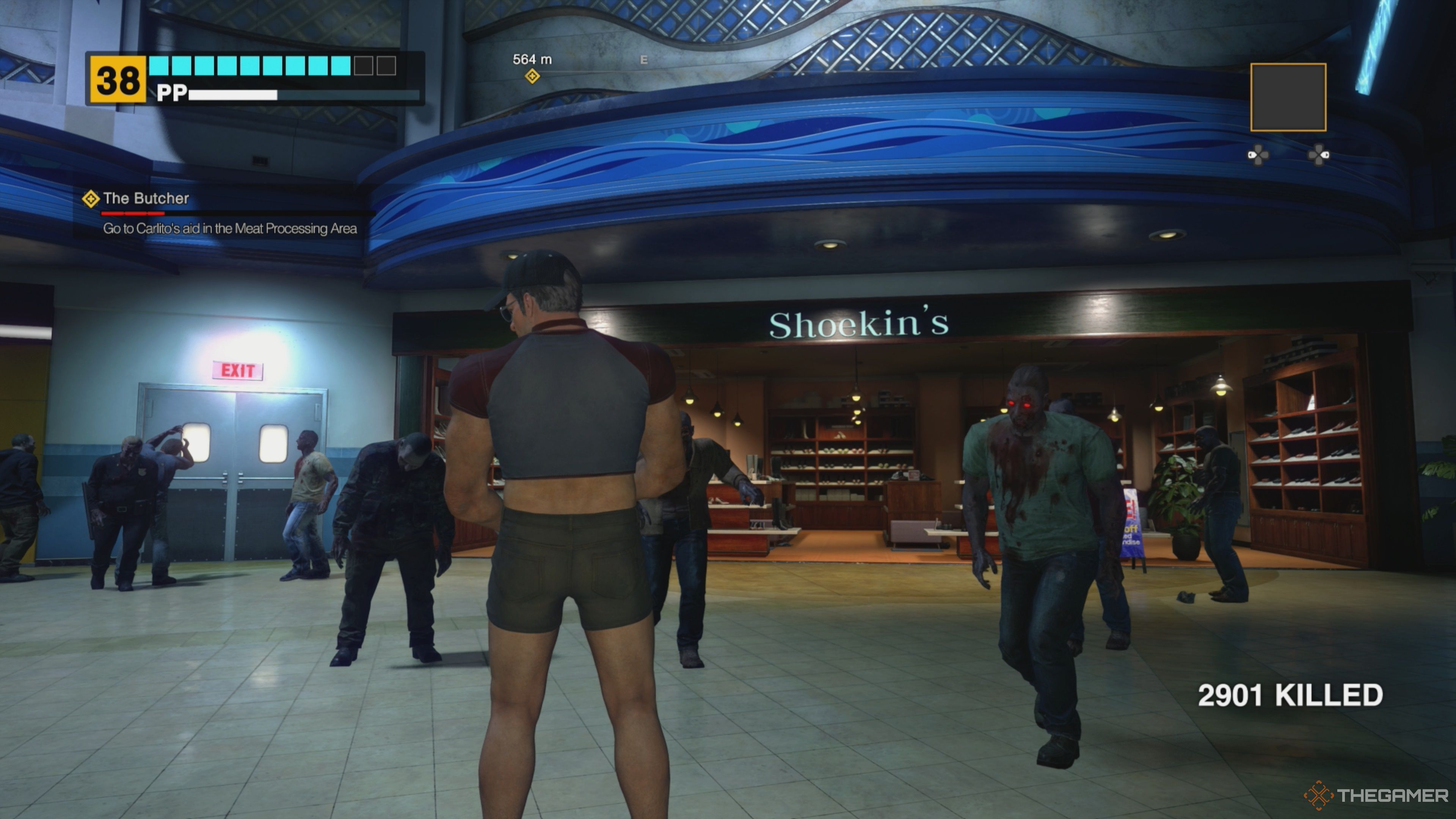 Frank West standing outside the Shoekin's Store in Paradise Plaza while a small group of zombies wander toward him in Dead Rising Deluxe Remaster.