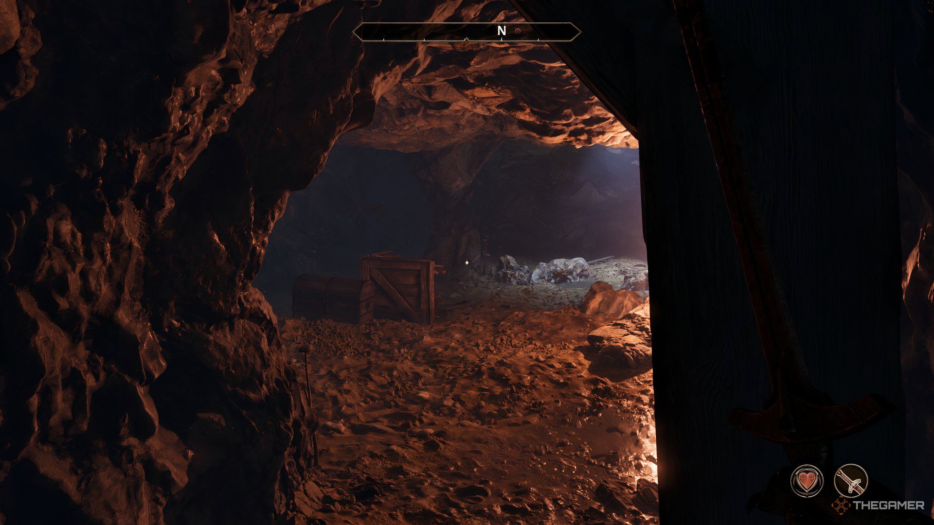 Player in a cave about to enter an open area. There is a box and chest in front with light coming from the right.