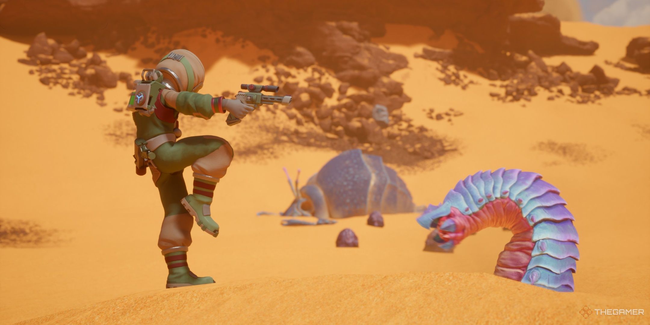 The player pointing a gun at a small worm in revenge of the savage planet.