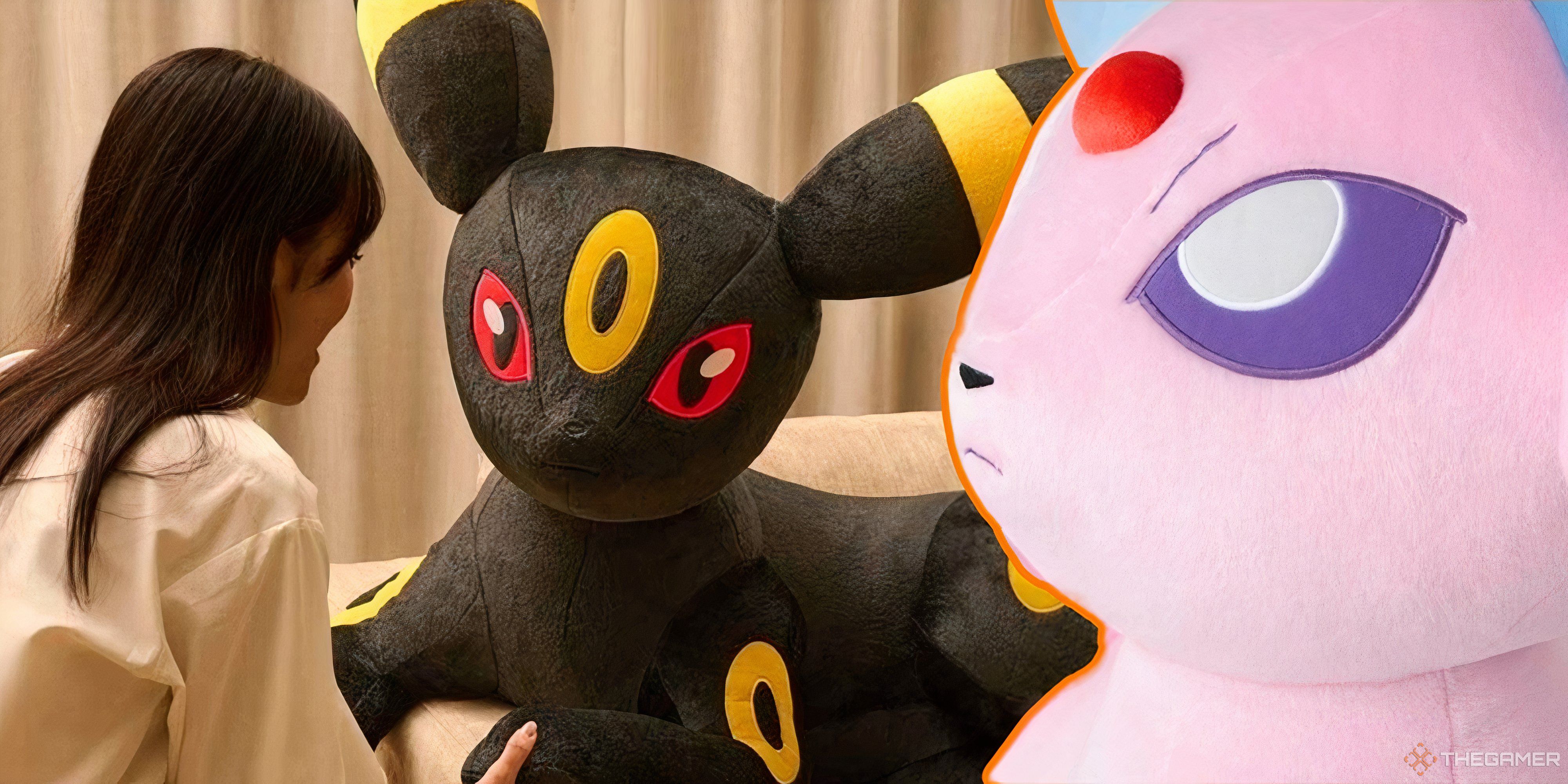 woman talking to a life size umbreon plush with a life size espeon plush in the foreground.