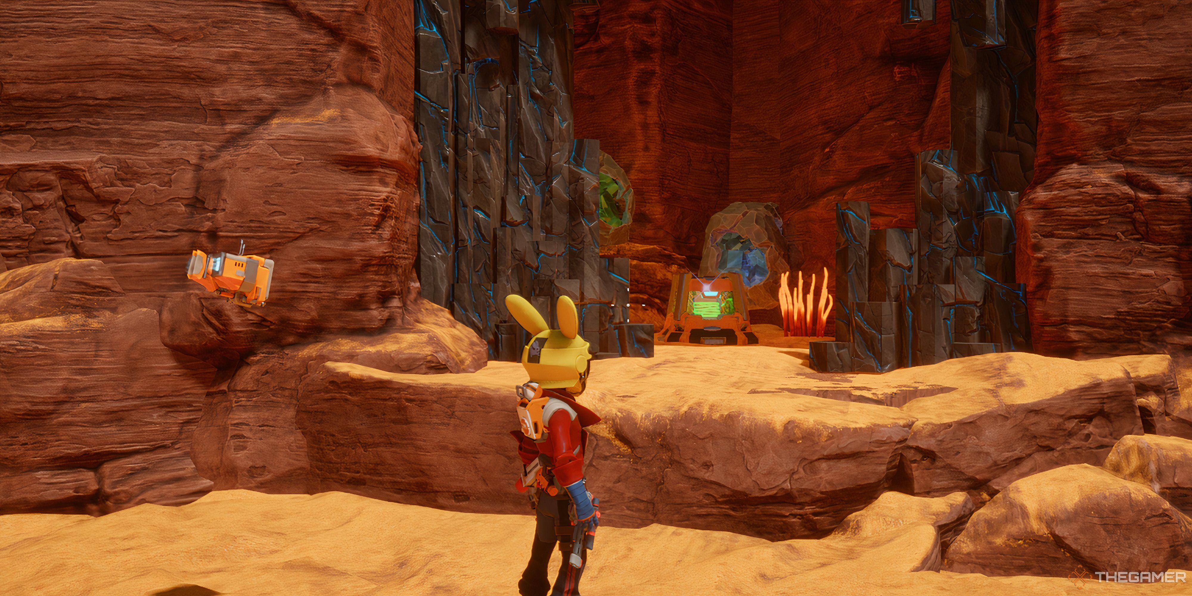 Player looking at Printer Slurry what is on a ledge in front of him. There are orange plants beside it with a blue and grey rock behind the crate in Revenge of the Savage Planet.