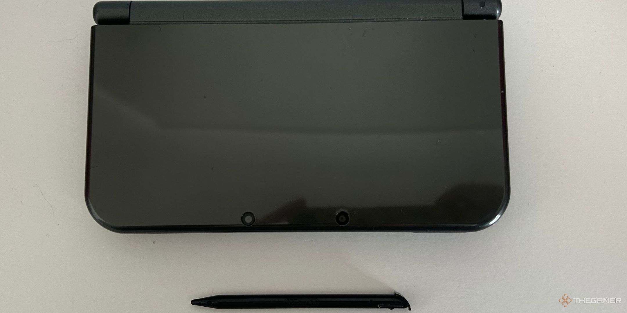 A Black 3DS with a stylus next to it.