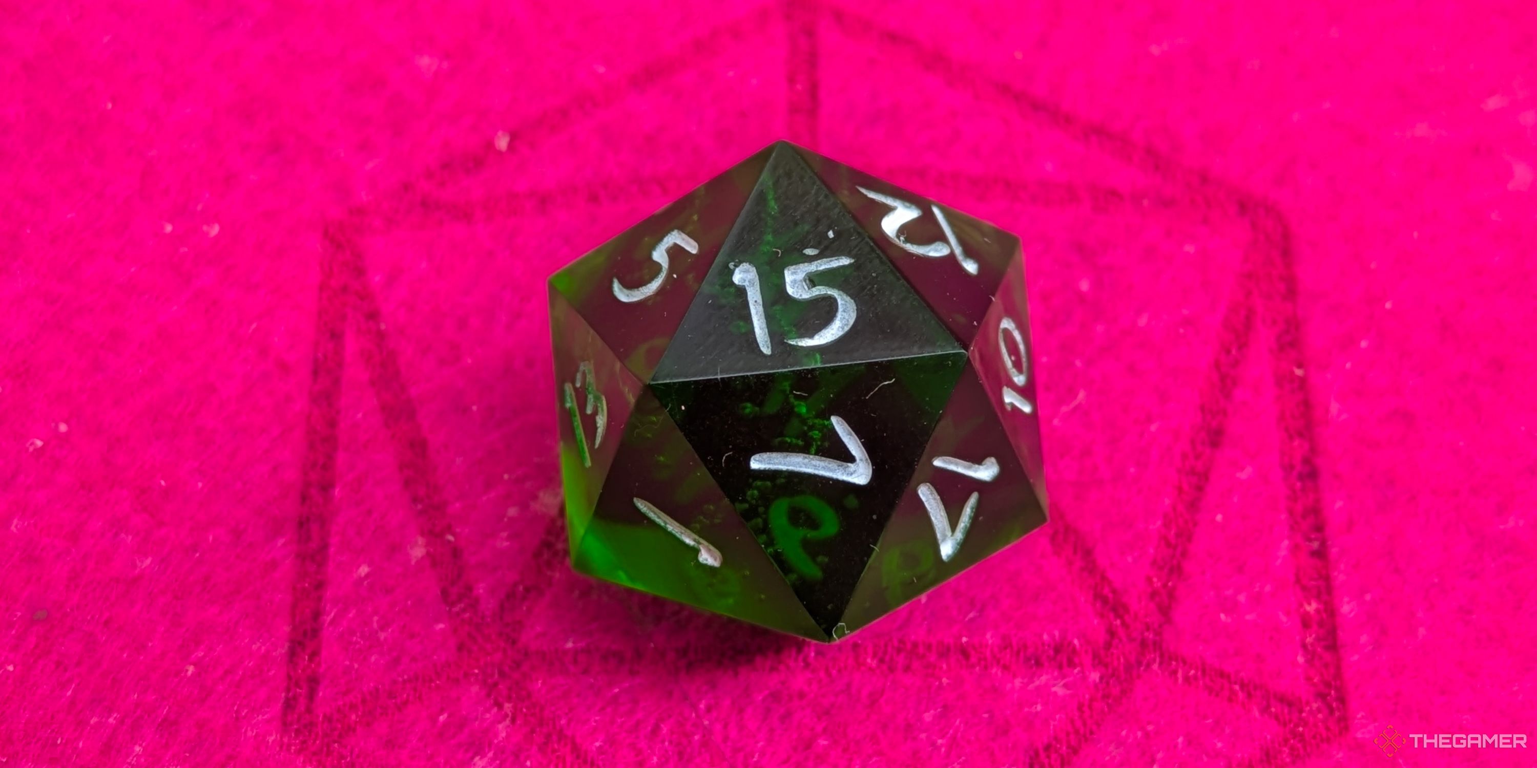 A close up shot of a D20 on red felt, showing a 15.