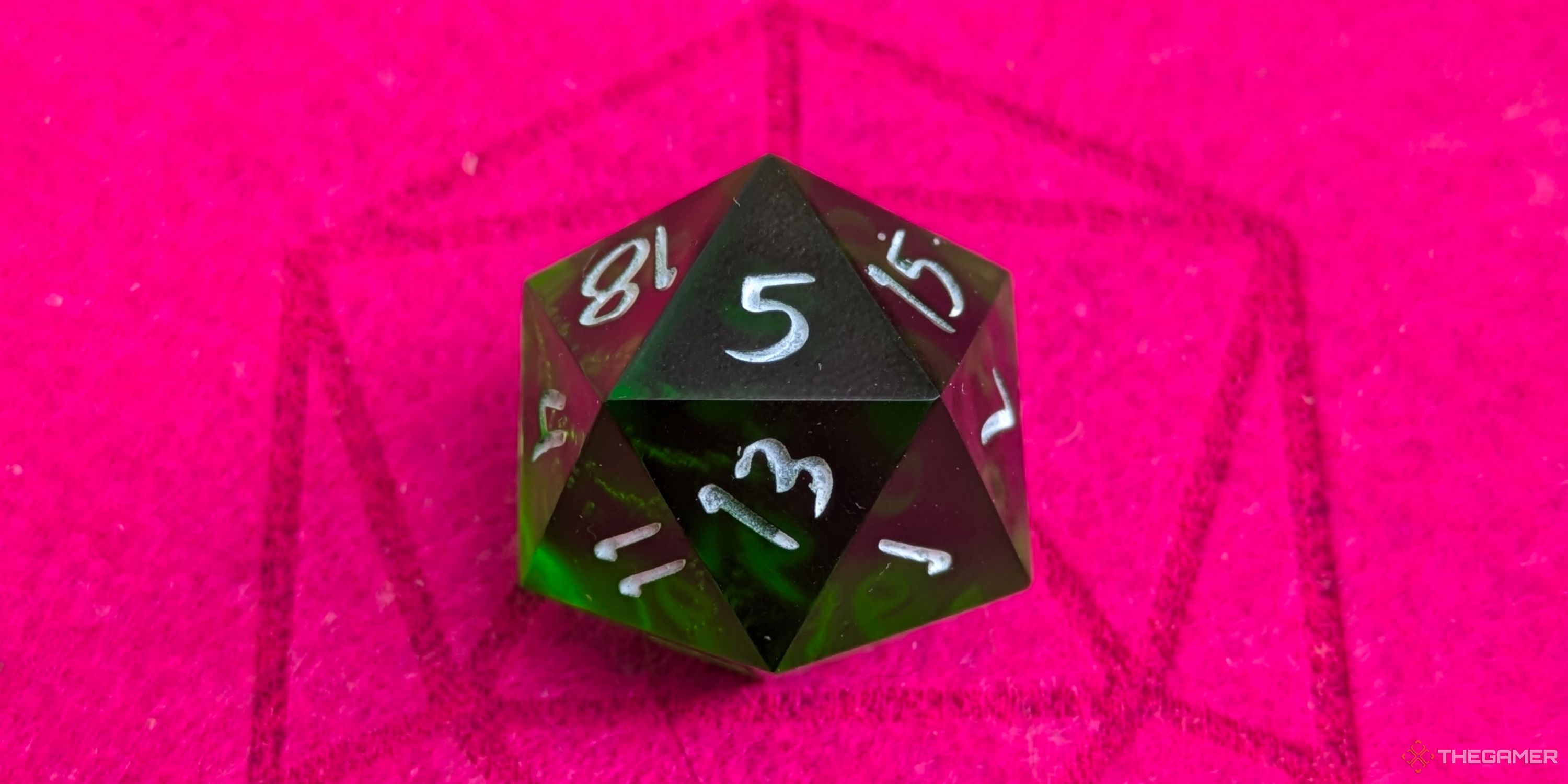 A close up shot of a D20 on red felt, showing a 5.