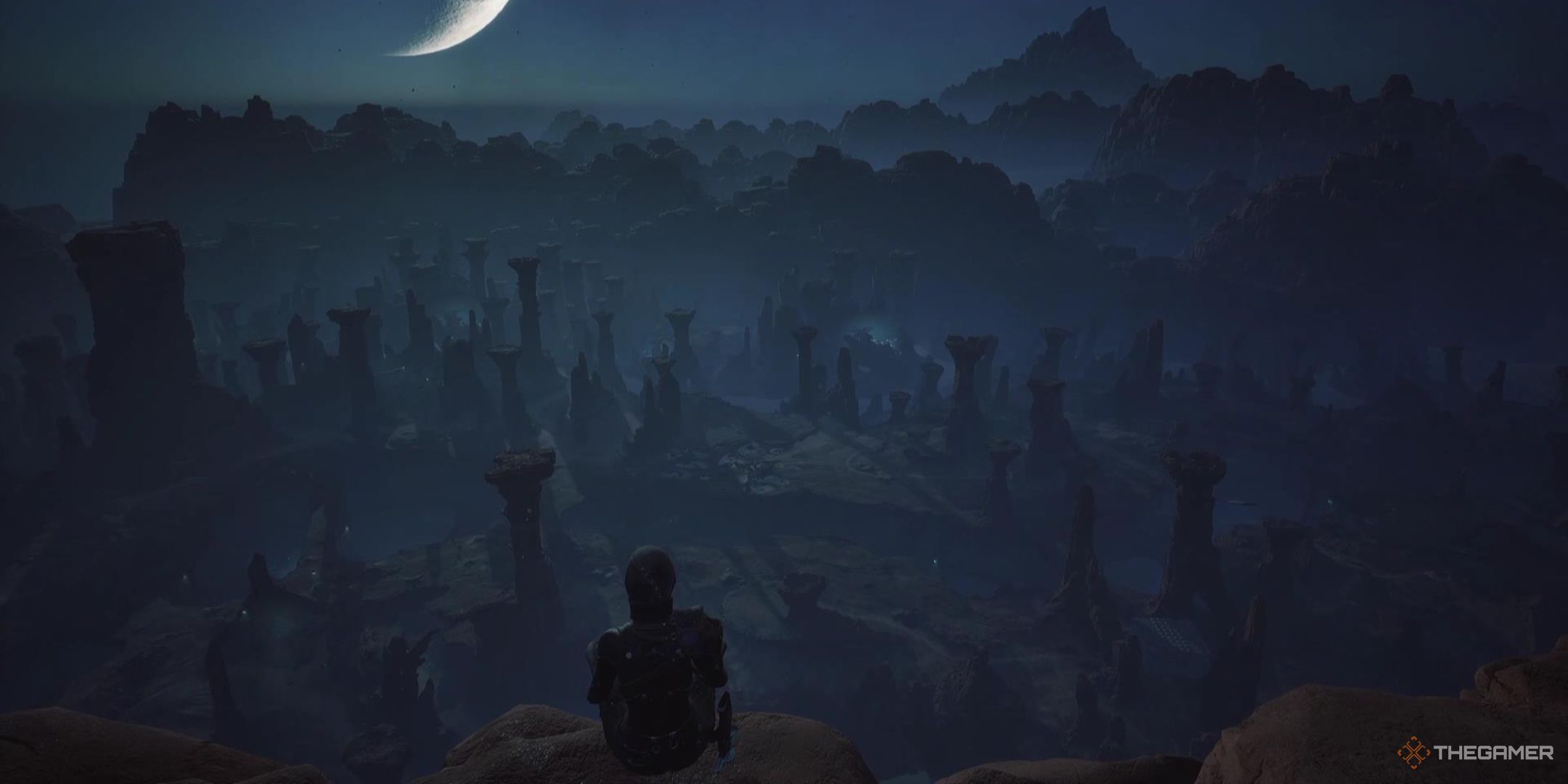 A character sits on top of a rock pillar overlooking spires dotting the desert in front of them at night in Dune Awakening.
