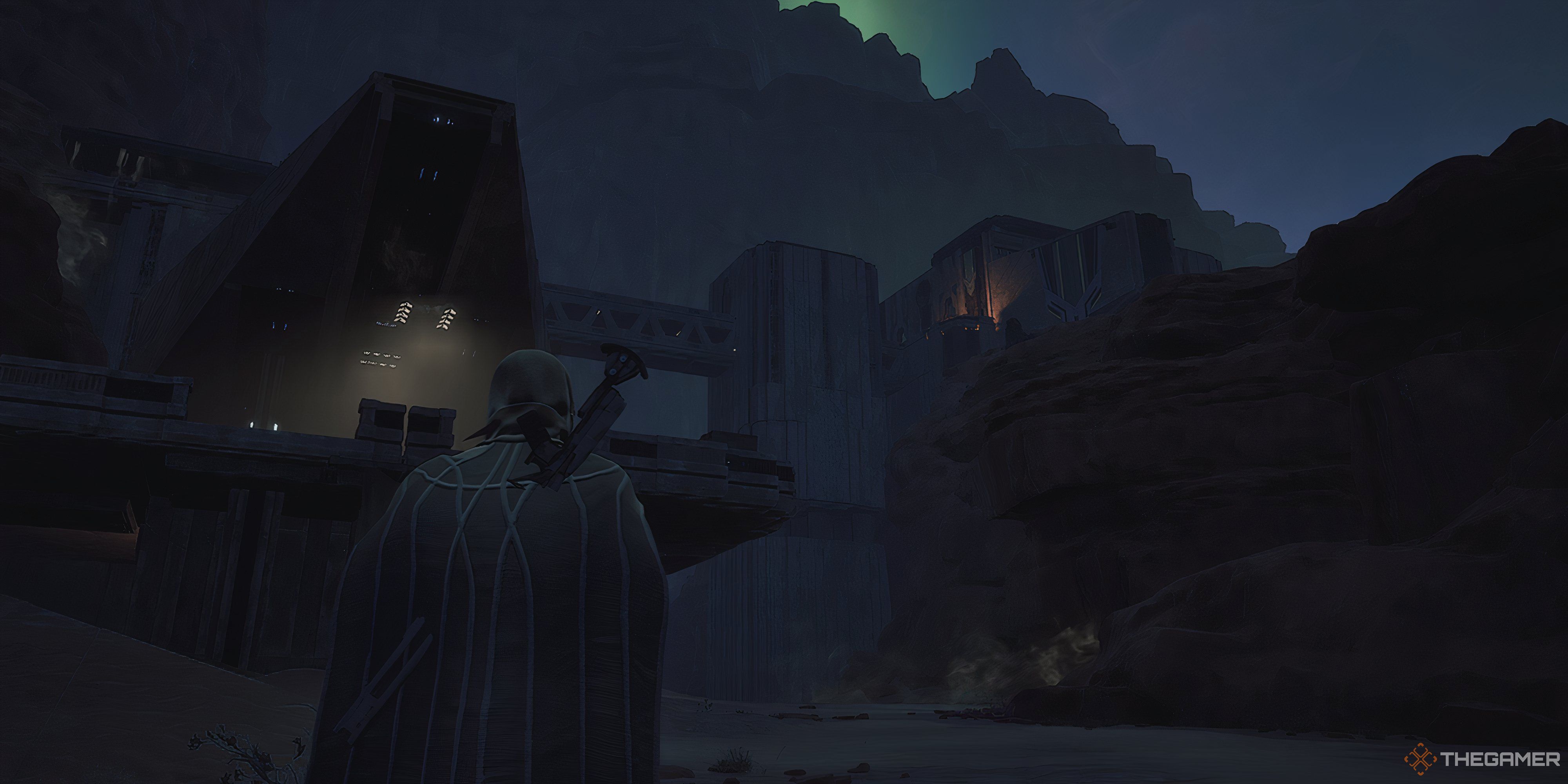 Player walking up to The Aegis stronghold in Dune: Awakening. There is mountain behind the base with green lights in the sky above. 