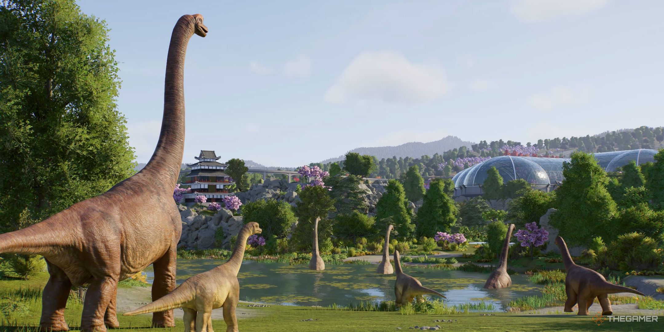 Jurassic World Evolution 3 A Brachiosaurus family overlooking a lake in thier enclosure.