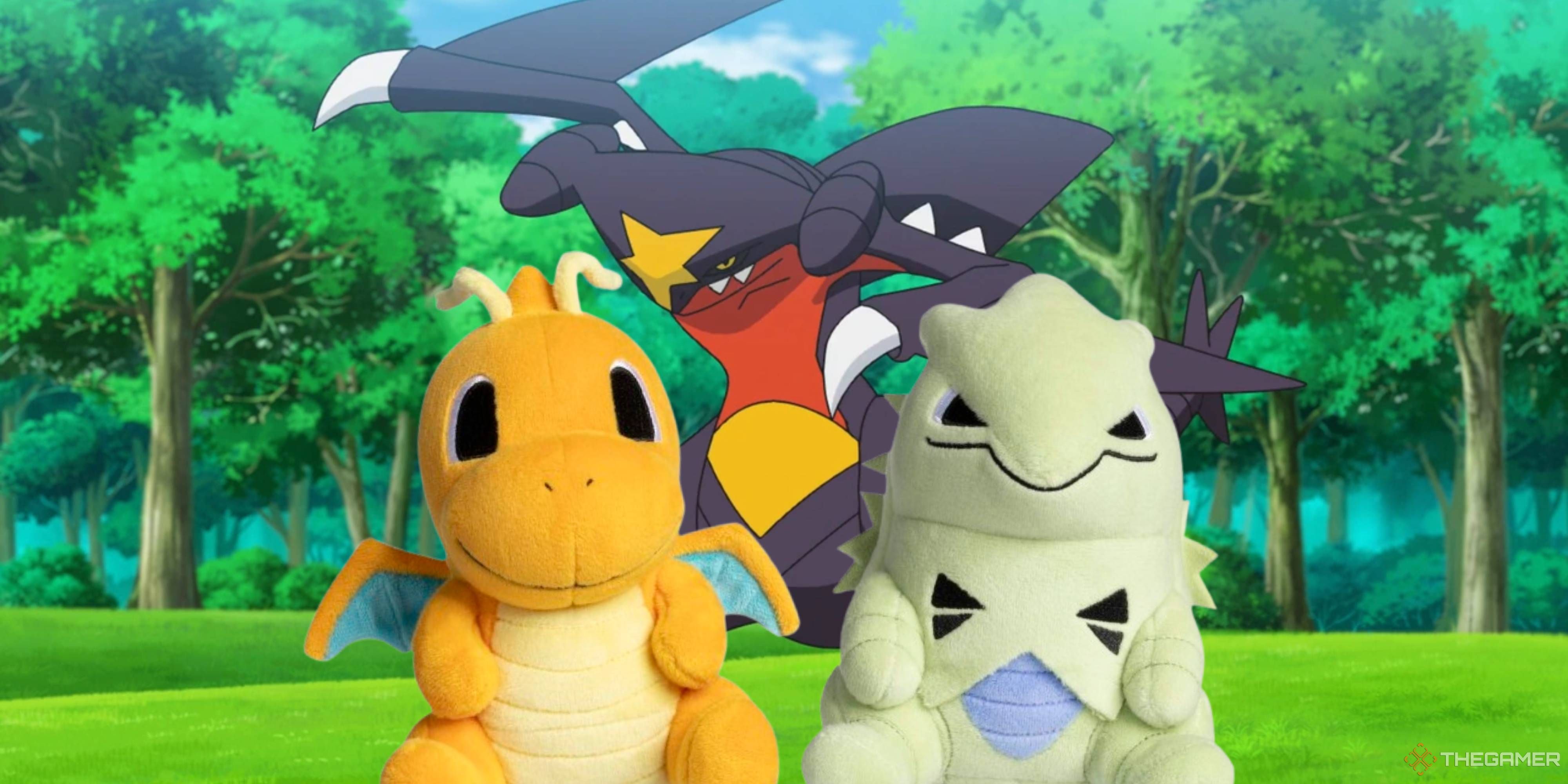 dragonite and tyranitar plushes in front of a garchomp.
