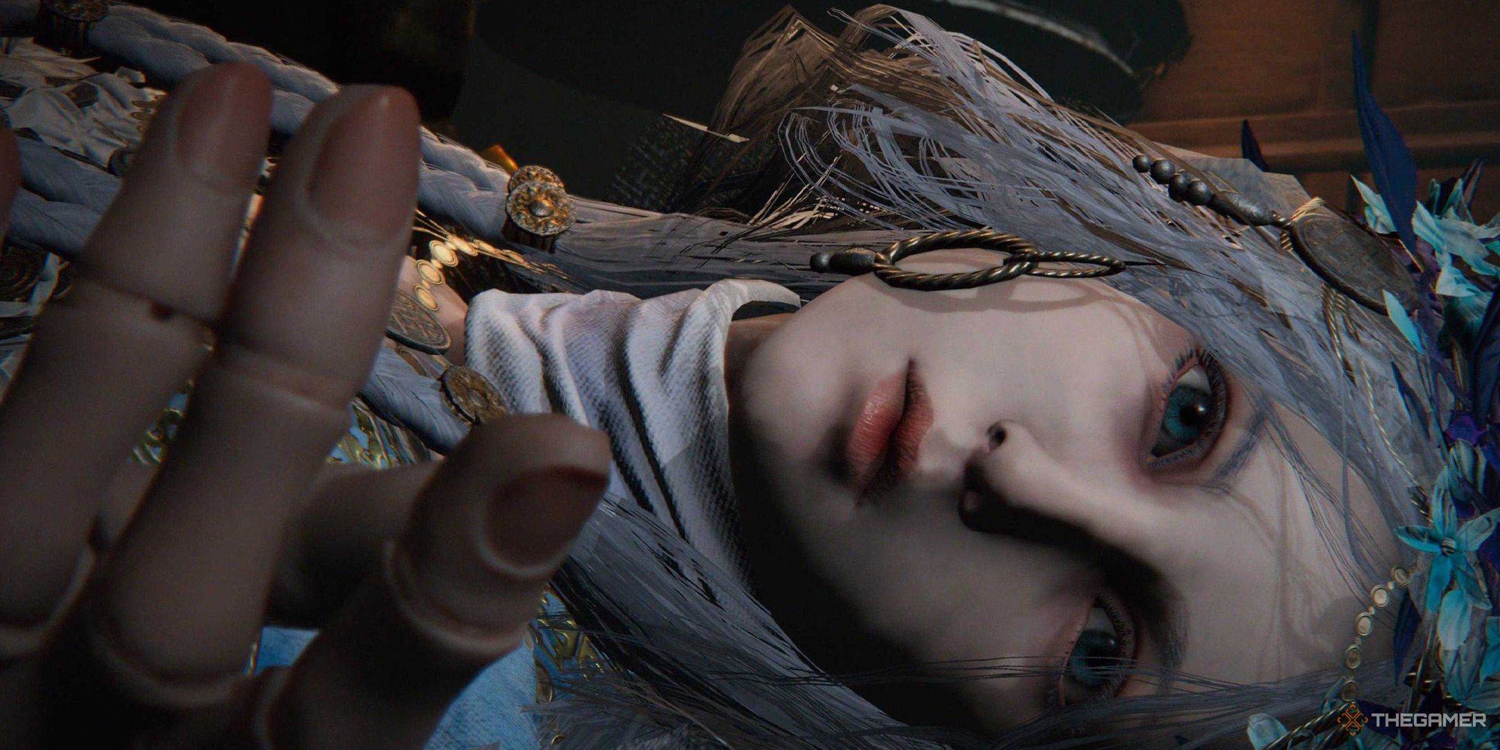 The Revenant lying on their side, completely still, in Elden Ring Nightreign. Their doll fingers are in focus.