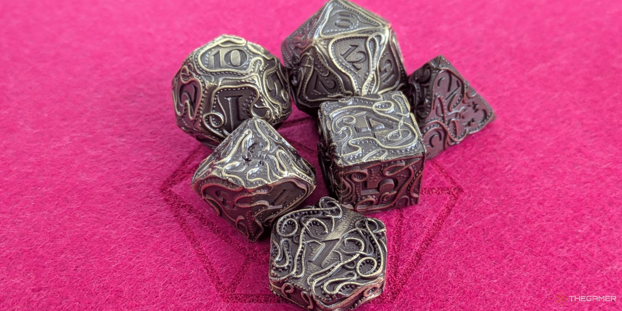 A close up of a set of kraken themed metal dice.