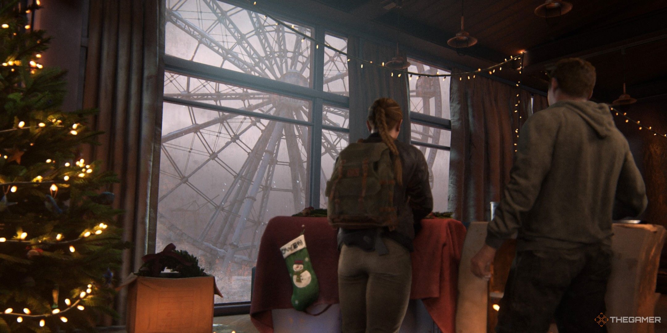 Abby and Owen from The Last of Us Part 2 surrounded by Christmas decorations, with a ferris wheel in the background.